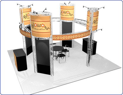 A circular exhibition booth with metal trusses, floral banners, black panels, tables, and spotlights.
